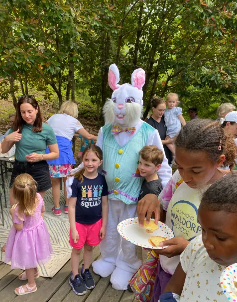 The Easter Bunny greets children gathered around.